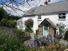 A cottage with a garden and a dining table at Mays Cottage in Wadebridge