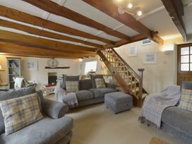 A living room with furniture and a staircase at Mays Cottage in Wadebridge