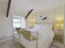 A bedroom with a bed and nightstands at Mays Cottage in Wadebridge