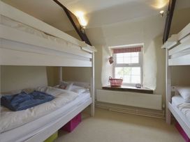A bedroom with bunk beds and a window at Mays Cottage in Wadebridge