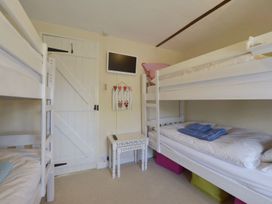 A bedroom with bunk beds and a television at Mays Cottage in Wadebridge