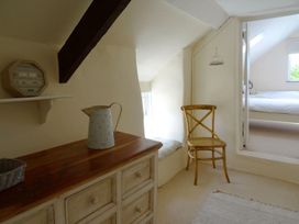 A bedroom with a dresser and a chair at Mays Cottage in Wadebridge