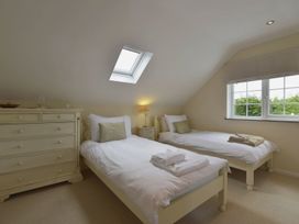 A bedroom with twin beds and a dresser at Mays Cottage in Wadebridge