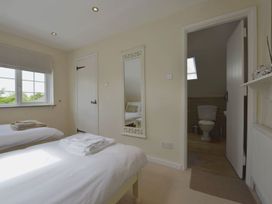 A bedroom with two beds and a mirror at Mays Cottage in Wadebridge