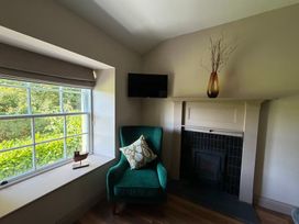 A snug with a green chair and a television at Kirkstone Brow in Ambleside