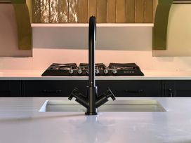 A kitchen with a sink and gas stove at Kirkstone Brow in Ambleside