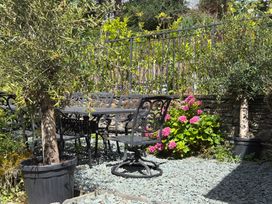 A garden with a table and chairs surrounded by flowers at Kirkstone Brow in Ambleside