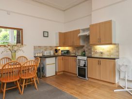A kitchen with a dining table and chairs at Apartment 2 in Torquay