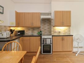 A kitchen with wooden cabinets and appliances at Apartment 2 in Torquay