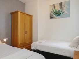 A bedroom with two beds and a wardrobe at Apartment 2 in Torquay