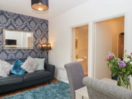 A living room with a sofa and a dining area at Apartment 4 in Torquay