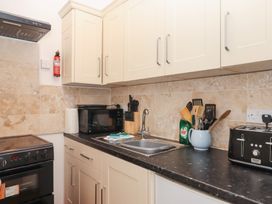A kitchen with an oven, microwave, sink, and kitchen utensils at Apartment 4 in Torquay