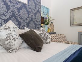 A bedroom with a bed and decorative pillows at Apartment 4 in Torquay