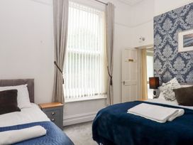 A bedroom with two beds and a window at Apartment 4 in Torquay