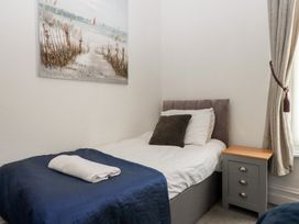 A bedroom with a single bed and a bedside table at Apartment 4 in Torquay