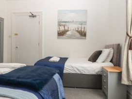 A bedroom with two beds and a painting at Apartment 4 in Torquay