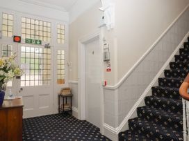 A hallway with a staircase and a door at Apartment 4 in Torquay