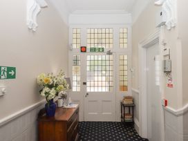 A hallway with a wooden table and flowers at Apartment 4 in Torquay