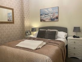 A bedroom with a bed and mirror at Apartment 5 in Torquay