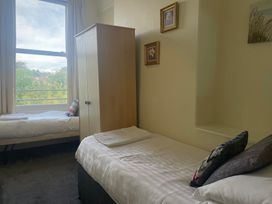 A bedroom with two beds and a wardrobe at Apartment 5 in Torquay