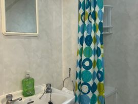 A bathroom with a sink and shower curtain at Apartment 6 in Torquay