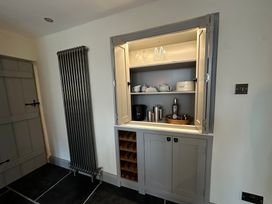 A cupboard with glasses and teapots in the kitchen at La'al Kirkstone Brow Ambleside