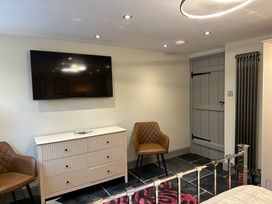 A bedroom with television and chairs at La'al Kirkstone Brow in Ambleside