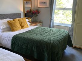 A bedroom with a bed and flowers on a table at Apartment 9 in Torquay