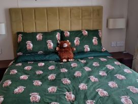 A bedroom with bed and pillows featuring a cow pattern at B2 in Lossiemouth