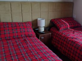A bedroom with two beds and a lamp at B2 in Lossiemouth