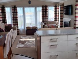 A living room with a sofa and TV at B2 in Lossiemouth