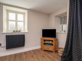 A living room with a television and window at Little Holm Garth