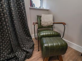 A chair and footrest in a sitting room at Little Holm Garth
