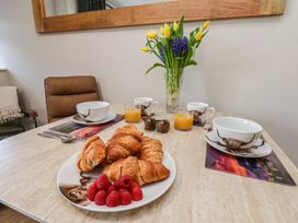 A dining room with croissants and raspberries on a table at Little Holm Garth
