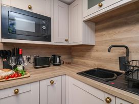 A kitchen with a microwave, sink, and kitchen appliances at Little Holm Garth