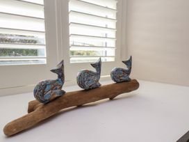 Three decorative figures on driftwood at Little Holm Garth in 
