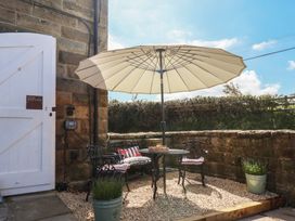 An outdoor seating area with a table and umbrella at Little Holm Garth