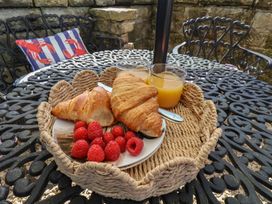 A croissant fruit and orange juice on a table at Little Holm Garth