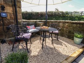 An outdoor seating area with a table and chairs under an umbrella at Little Holm Garth