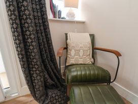 A living room with a green armchair and footrest at Little Holm Garth in Whitby