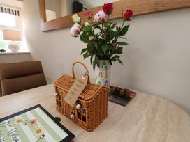 A dining room with flowers in a vase and a basket on a table at Little Holm Garth in Whitby