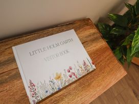 A visitor book on a wooden table at Little Holm Garth in Whitby