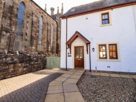 An outdoor view of a house with a pathway and gate at Derwent Cottage in Cockermouth