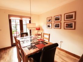 A dining room with a table set for dinner at Derwent Cottage in Cockermouth
