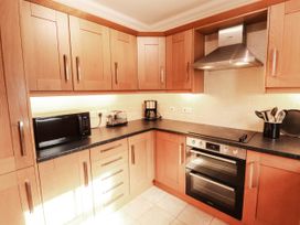 A kitchen with appliances and cabinets at Derwent Cottage in Cockermouth