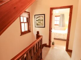 A hallway with a staircase and door leading to a bedroom at Derwent Cottage Cockermouth