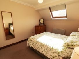 A bedroom with a bed and a dresser at Derwent Cottage in Cockermouth
