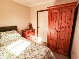 A bedroom with a bed and furniture at Derwent Cottage in Cockermouth