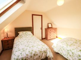 A bedroom with two beds and a dresser at Derwent Cottage in Cockermouth