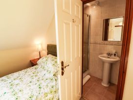 A bedroom with a bed and an attached bathroom at Derwent Cottage in Cockermouth